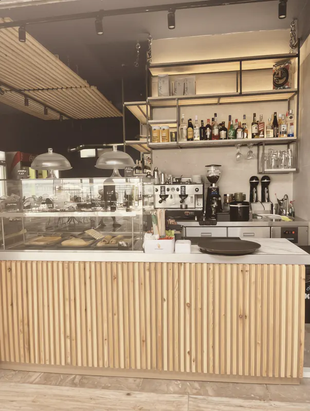 The OKKIO bar counter with a coffee machine and bottles on shelves