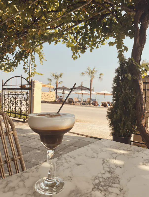 Iced freddo espresso on a table in the shade at OKKIO